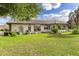 Back exterior view of home with lush landscaping at 6178 Spinnaker Loop, Lady Lake, FL 32159