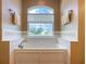 Relaxing bathroom featuring a soaking tub and a large window at 1010 Nantucket Sound, Mount Dora, FL 32757