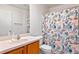 Clean bathroom with wood cabinets, a shower/tub, and a patterned curtain at 17478 Se 77Th Sycamore Ave, The Villages, FL 32162
