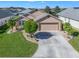 Single-story home with attached garage, manicured lawn, and palm trees at 17775 Se 125Th Cir, Summerfield, FL 34491