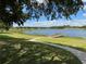 Scenic lakefront view with a wooden dock and walking path at 21630 King Henry Ave, Leesburg, FL 34748