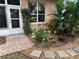 Landscaped garden with brick path, lush plants, and a white door at 21630 King Henry Ave, Leesburg, FL 34748