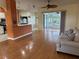 Bright living room with hardwood floors, view of kitchen and access to a screened porch at 21630 King Henry Ave, Leesburg, FL 34748