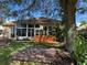 Home exterior with a swing, deck, lush landscaping, and large tree at 21630 King Henry Ave, Leesburg, FL 34748