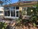 Home exterior with sunroom, landscaping, and brick pathway at 21630 King Henry Ave, Leesburg, FL 34748
