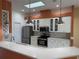 Modern kitchen with white cabinets, stainless steel appliances, and a breakfast bar at 21630 King Henry Ave, Leesburg, FL 34748
