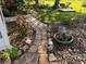 Stone path meanders through garden with fountain and flowers at 21630 King Henry Ave, Leesburg, FL 34748