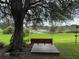 Relaxing swing on deck overlooking a serene pond at 21630 King Henry Ave, Leesburg, FL 34748
