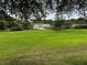 Spacious backyard with lush grass and tranquil pond view at 21630 King Henry Ave, Leesburg, FL 34748