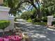 Paved road leading into a residential community with lush landscaping at 21630 King Henry Ave, Leesburg, FL 34748