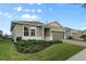 Single story home with green garage door and neatly landscaped front yard at 256 Silver Maple Rd, Groveland, FL 34736