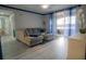 Bright living room with sectional sofa, large windows, and access to balcony at 3406 Soho St # 102, Orlando, FL 32835