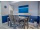 Dining area with gray table and chairs, blue accent wall, and artwork at 3406 Soho St # 102, Orlando, FL 32835