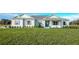 Exterior of a one-story home with light siding, landscaping, and a large yard at 38805 Ranch Gate Blvd, Umatilla, FL 32784