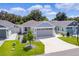 One-story house with gray garage door and small front yard at 5238 Dalessandro Rd, The Villages, FL 32163