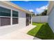 Side yard view of a house, showing a patio and grassy lawn at 5238 Dalessandro Rd, The Villages, FL 32163