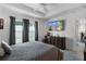 Bright bedroom with a large TV and gray bedding at 5238 Dalessandro Rd, The Villages, FL 32163