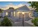 Charming one-story house with gray garage door, light blue accents and landscaping at 5238 Dalessandro Rd, The Villages, FL 32163