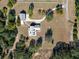 High-angle view showcasing a house, detached garage, and ample land at 7620 Arrow Ln, Yalaha, FL 34797