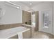 Bathroom with soaking tub, walk-in shower, and pool view at 1603 Lima Ave, Kissimmee, FL 34747