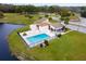 Community pool and clubhouse near a pond at 22103 Sandalwood Dr # 103, Wildwood, FL 34785