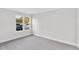 Bright bedroom with grey carpet and window view of parking lot at 22103 Sandalwood Dr # 103, Wildwood, FL 34785