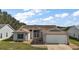 Single-story house with attached garage and landscaped yard at 25114 Meriweather Rd, Leesburg, FL 34748