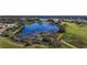 Aerial view of a community with a lake, golf course, and houses at 25114 Meriweather Rd, Leesburg, FL 34748