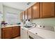 Bright laundry room with washer, dryer, and ample cabinet storage at 25114 Meriweather Rd, Leesburg, FL 34748