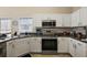 Modern kitchen with stainless steel appliances and white cabinets at 25114 Meriweather Rd, Leesburg, FL 34748
