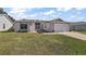 Single-story home with light-colored siding and a two-car garage at 25114 Meriweather Rd, Leesburg, FL 34748