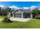 Gray house with a three-car garage and landscaped lawn at 3927 Oak Pointe Dr, Lady Lake, FL 32159