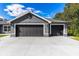 Two-car garage with dark gray doors and a concrete driveway at 3927 Oak Pointe Dr, Lady Lake, FL 32159