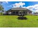 Gray house with large windows, patio, and grassy backyard at 3927 Oak Pointe Dr, Lady Lake, FL 32159