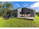 Gray house with large windows, patio, and grassy backyard at 3927 Oak Pointe Dr, Lady Lake, FL 32159