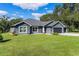 Gray house with gray roof, two-car garage, and landscaping at 3927 Oak Pointe Dr, Lady Lake, FL 32159