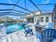Relaxing pool and spa with screened enclosure and blue chairs at 405 Amola Way, Howey In The Hills, FL 34737