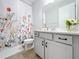 Clean bathroom with a floral shower curtain, modern vanity, and tile floor at 405 Amola Way, Howey In The Hills, FL 34737