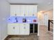 Convenient wet bar with white cabinets, a sink, and wine cooler at 405 Amola Way, Howey In The Hills, FL 34737