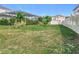 Landscaped backyard with a grassy area, tropical plants, and a covered patio at 405 Amola Way, Howey In The Hills, FL 34737