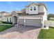 Two-story house with stone accents, three-car garage, and manicured lawn at 405 Amola Way, Howey In The Hills, FL 34737