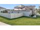 House exterior showcasing a two-story home with solar panels and a fenced yard at 405 Amola Way, Howey In The Hills, FL 34737