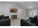 Bright living room with two black sofas, wood-look floors, and a large TV at 414 2Nd St, Ocoee, FL 34761