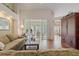 Living room with hardwood floors, green couch and sunroom view at 4803 Sawgrass Lake Cir, Leesburg, FL 34748
