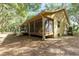Tan house exterior with a screened porch and surrounding trees at 9442 Cr 674, Bushnell, FL 33513