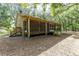 Side view of house, screened porch, wooden steps, and wooded area at 9442 Cr 674, Bushnell, FL 33513