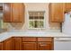 Kitchen features oak cabinets, a double sink, and a window overlooking the backyard at 9442 Cr 674, Bushnell, FL 33513