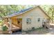 Tan house exterior with a large wrap-around porch and surrounding trees at 9442 Cr 674, Bushnell, FL 33513