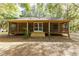 Back of house, screened porch, wooden steps, and wooded area at 9442 Cr 674, Bushnell, FL 33513