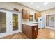 Kitchen with wood cabinets, island, and access to screened porch at 9442 Cr 674, Bushnell, FL 33513